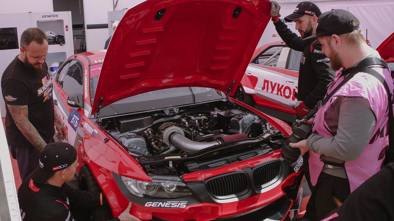 Technicians working on a red racing car